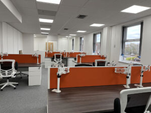 Office desks and seating with corporate colour screens
