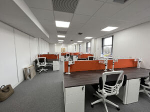 Office desks and seating with corporate colour screens
